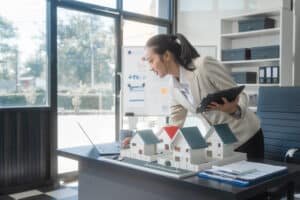 Property management tips in Phuket: Real estate agent analyzing property models.