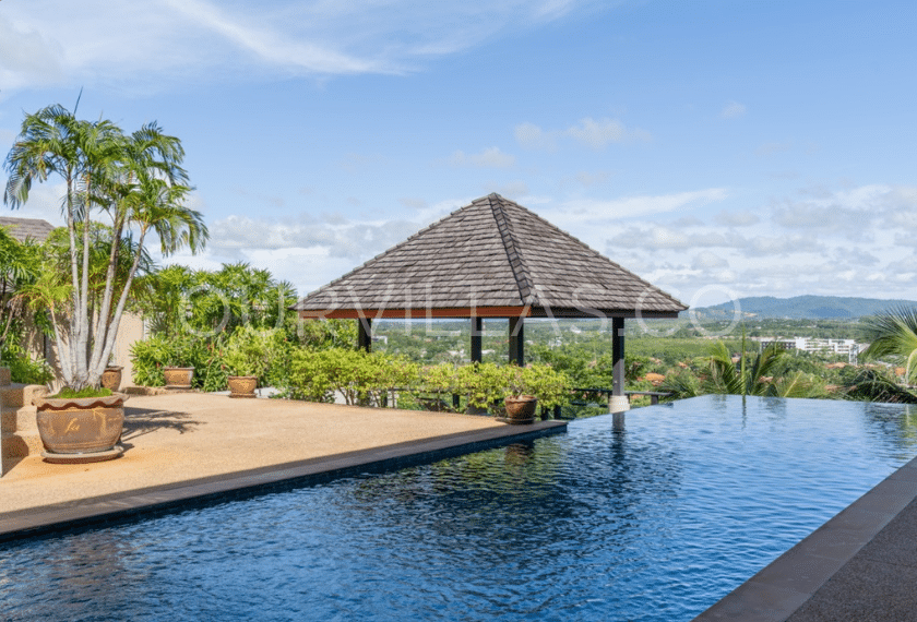 Infinity pool villa in Phuket with a mountain and city view.