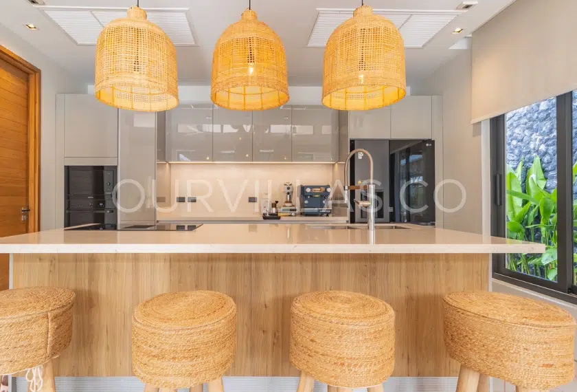 Modern kitchen with rattan pendant lights and island.