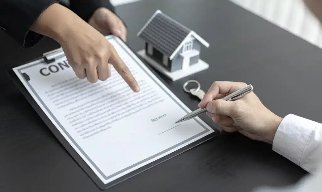 Signing a real estate contract with house model.