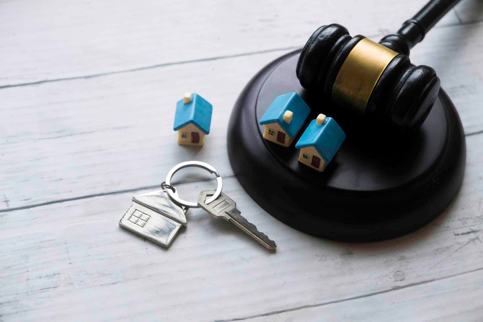 Gavel, house key, and miniature homes.