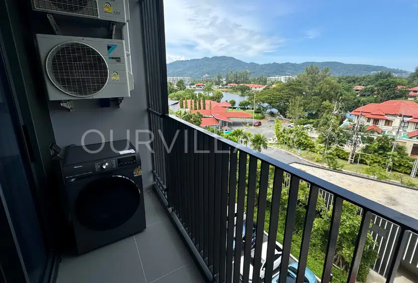 Condo balcony with scenic hillside and city views.