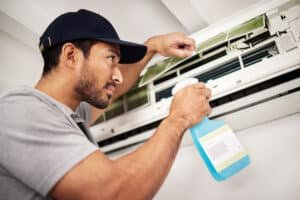 Air Conditioner Cleaning Service in Phuket: Technician cleaning an air conditioner unit.