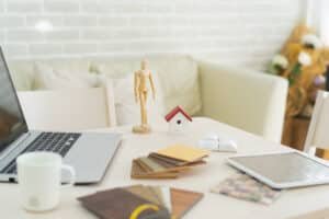 Managing Rental Properties in Thailand: A workspace with home design samples and a laptop.