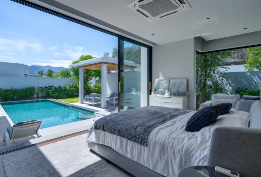 Luxury bedroom with a pool and garden view.