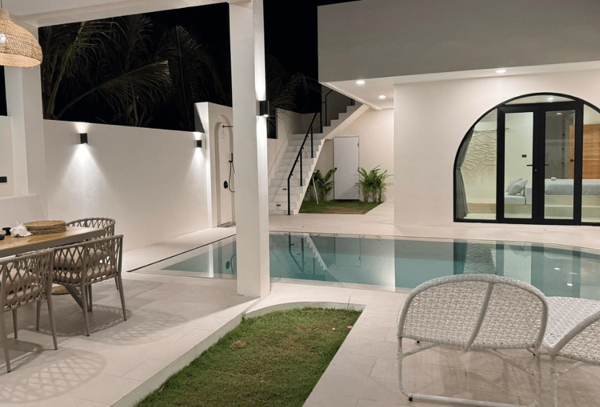 Modern white villa with pool at night