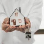 Buying Property in Thailand as a Foreigner: A person holding a house model and keys.