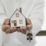 Buying Property in Thailand as a Foreigner: A person holding a house model and keys.