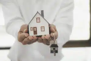 Buying Property in Thailand as a Foreigner: A person holding a house model and keys.