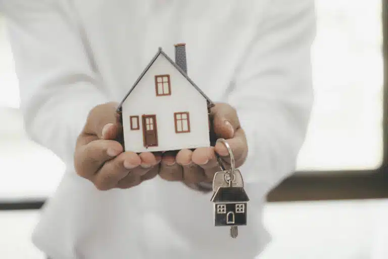 Buying Property in Thailand as a Foreigner: A person holding a house model and keys.