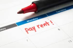 Late Rent Payments: Calendar with "pay rent!" reminder written in red marker.
