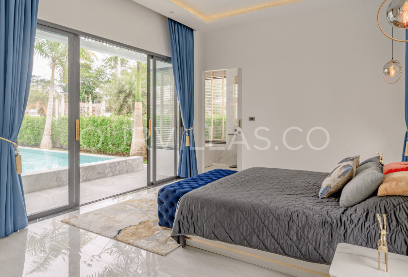 Modern bedroom with pool view and blue curtains