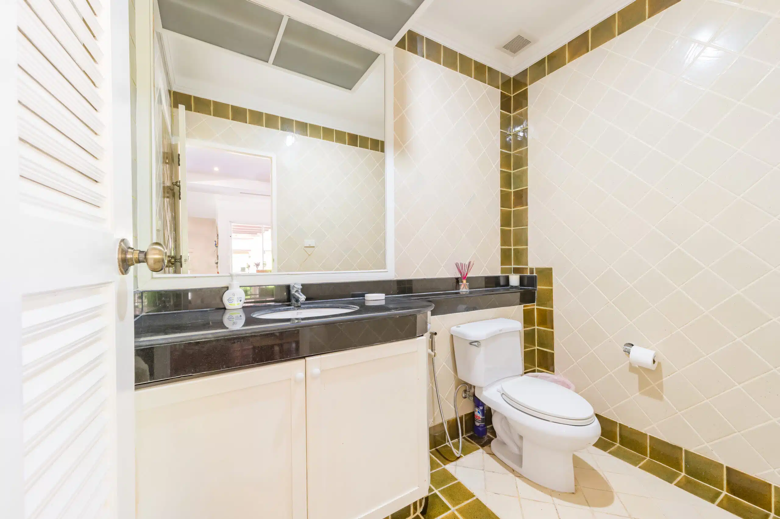 Guest toilet with tiled walls and black vanity top