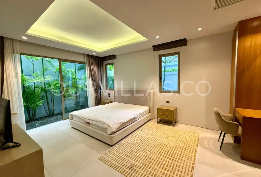 Guest bedroom with large window and work desk