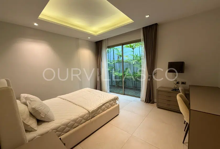 Second villa bedroom with glass doors and garden